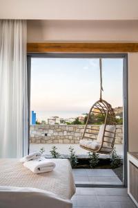 阿彻奇洛斯Lithos Luxury Villa的一间卧室设有秋千床和一个庭院。