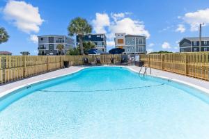 橡树岛The Beach House at Oak Island by Carolina Resorts的一个带木栅栏的大型游泳池