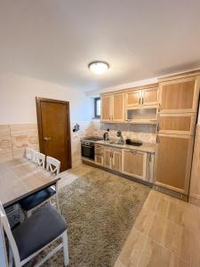 普拉夫Apartments & Rooms Brijest的厨房配有木制橱柜和桌椅