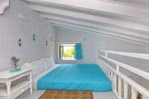 AgnontasVilla Potami的白色卧室设有蓝色的床和窗户