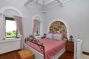 AgnontasVilla Potami的一间卧室配有一张带粉色床单的床和一扇窗户。