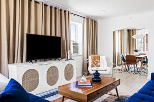 丹佛Bright & Modern Retreat - King Beds - Sloans Lake的客厅配有白色橱柜上的平面电视