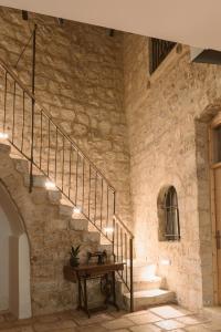 耶路撒冷William's Guest House的石头建筑中的楼梯,配有木桌