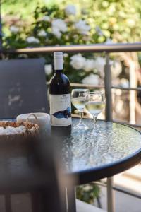 卡特罗斯Villa Emmanuel的桌子上放有一瓶葡萄酒和两杯酒