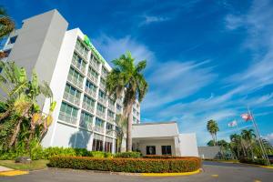 马亚圭斯马亚圭斯假日酒店和热带赌场的一座楼前有棕榈树的酒店