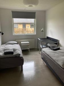 维比Villa med private værelser delt badeværelse/køkken, viby sj.的一间卧室设有两张床、一张桌子和一个窗口。