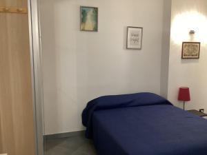 Verano BrianzaIl nido di Pietro的卧室配有蓝色的床,墙上挂有图片