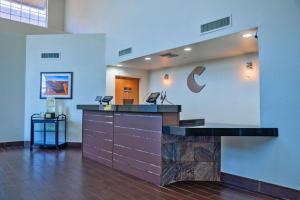 谢拉维斯塔Comfort Inn & Suites Sierra Vista near Ft Huachuca的大堂设有前台,墙上挂有公司标志