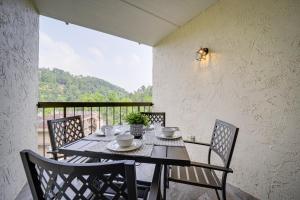 加特林堡Stylish Gatlinburg Condo with Pool Walk Downtown!的阳台的用餐室配有桌椅