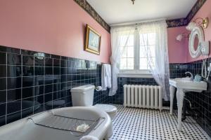 尼亚加拉瀑布板栗酒店的带浴缸、卫生间和盥洗盆的浴室