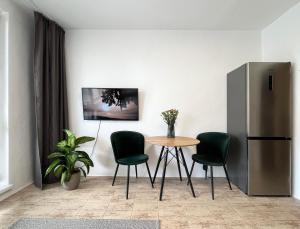 布拉迪斯拉发New cozy studio, private parking的厨房配有桌椅和冰箱。