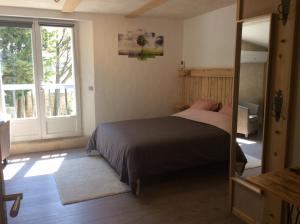 DonzèreLe Mas des Figuiers的一间卧室设有一张床和一个大窗户