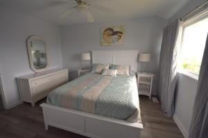 翡翠岛Oceanfront vacation property - West的一间卧室配有一张床、镜子和窗户