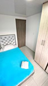 佩雷拉Apartahotel222 Pereira 403的一间卧室设有蓝色的床和木门