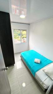 佩雷拉Apartahotel222 Pereira 403的一间卧室设有蓝色的床和窗户。