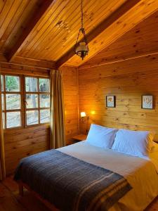 圣阿方索Rancho el Chilcal Cabañas con vista al rio的小木屋内一间卧室,配有一张床