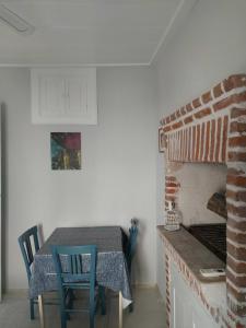艾瓦勒克Mimosa House Ayvalık的厨房配有砖炉和桌椅