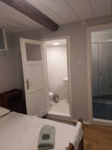 艾瓦勒克Mimosa House Ayvalık的一间卧室配有一张床,浴室设有淋浴。