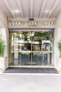 洛哈Grand Hotel Loja的带有读取宏伟酒店外观标志的商店窗口