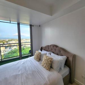 马尼拉Suite M - 1 Bedroom Condo at Azure Residences的一间卧室设有一张大床和大窗户