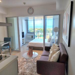 马尼拉Suite M - 1 Bedroom Condo at Azure Residences的客厅配有沙发和1张床