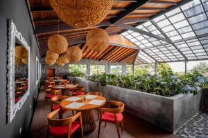 蒙泰韦尔德哥斯达黎加厄尔爱斯达梦泰恩酒店的餐厅设有木桌和椅子,种有植物