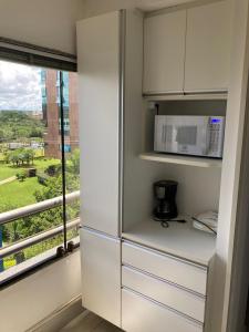 巴西利亚Flats Asa Norte CLN 213 by CentoEdez的厨房配有微波炉和窗户。
