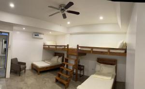黎牙实比P&B Residences Legazpi的客房设有两张双层床和吊扇。