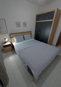 MesimvríaAndre House的一间卧室配有一张大床和木制床头板