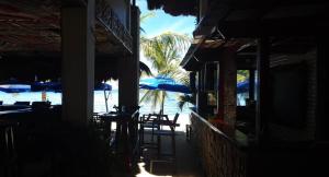 邦劳birdwatchers beachfront hotel panglao的海滩上设有1间带椅子和遮阳伞的餐厅