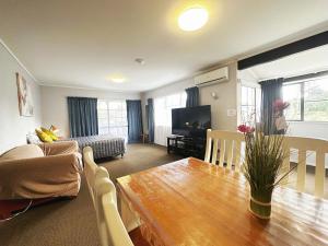 旺阿雷金斯伍德庄园汽车旅馆的客厅配有桌子、沙发和电视