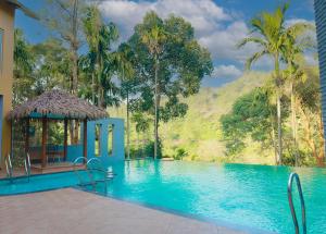 VayittiriMaple Ash Resort的一座带凉亭的游泳池,毗邻一座山