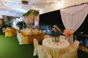 长滩岛Boracay Grace Hotel的宴会厅配有桌椅和鲜花