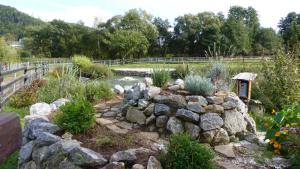 Blatterlhof的一个带岩石墙和池塘的花园