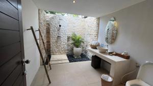圣吉吉生活亚洲度假酒店的一间带石质淋浴和水槽的浴室