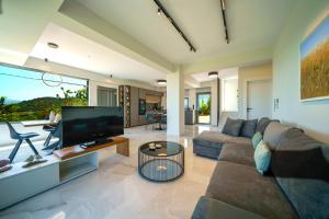PerivóliaMythic Olive villa - Heated Pool - Amazing view的带沙发和电视的客厅