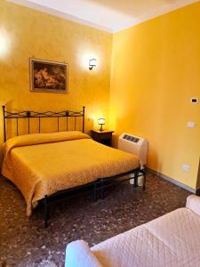 丰迪Bed And Breakfast Camere Primavera的黄色客房,设有两张床和散热器
