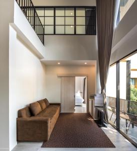 武里南T-REX BURIRAM BOUTIQUE HOTEL New Hotel in Buriram的客厅配有沙发和1张床
