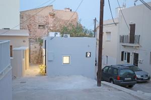 埃尔莫波利斯Cozy By Syros Bnb的停在白色建筑旁边的停车场的汽车