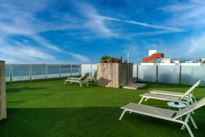 伊维萨镇Apartamentos Llobet Ibiza的阳台配有躺椅,享有海景。