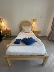 Moyo IslandBlue EmOcean resort的一间卧室配有一张带两套蓝色手套的床。