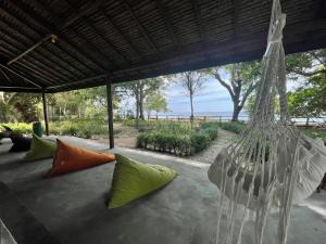 Moyo IslandBlue EmOcean resort的天井上配有带色彩缤纷枕头的吊床