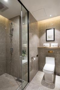 长沙莫林酒店长沙省政府地铁站店的一间带卫生间和玻璃淋浴间的浴室
