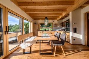 茨维泽尔Kroner Chalets的厨房以及带木桌和椅子的用餐室。