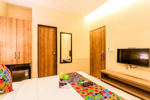 孟买FabExpress Ascot International Andheri East的客房设有一张床和一台平面电视。