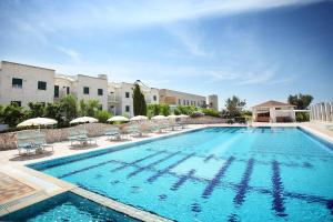 托雷桑塔萨宾娜Calanca Apulian Residence的一个带椅子和遮阳伞的大型游泳池