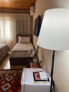 吉诺卡斯特Marko's House的一间卧室配有一张床和一张带台灯的桌子
