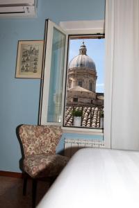 阿西西Case di Anna的一间卧室配有椅子,享有建筑的景色