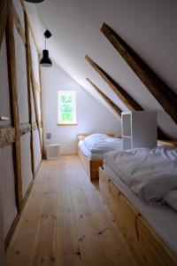 DassowGutshaus FeWo Brook的阁楼卧室设有两张床,铺有木地板。
