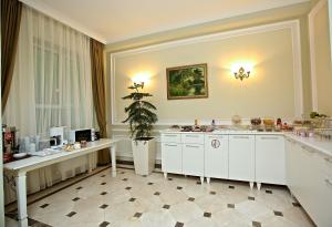 巴库Miraj hotel的厨房配有白色橱柜和盆栽植物